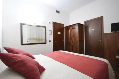 a bedroom with a large bed with red pillows at Guest House Planet 29 in Rome