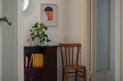 a chair sitting next to a book shelf with a plant at Casa Luisa - WelcomeToRhome in Rome