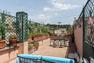 a balcony with chairs and tables on a patio at Terrazza di Flamy - WelcomeToRhome in Rome
