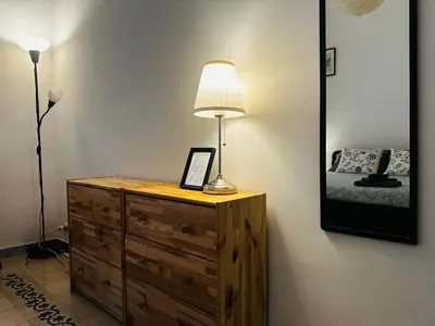 a lamp sitting on a dresser next to a bedroom at Little Colosseum Gem in Rome
