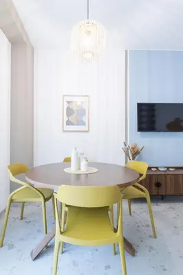 a dining room with a table and yellow chairs at Vacanze romane - Domus chic Trastevere - Marconi by Hôtea in Rome