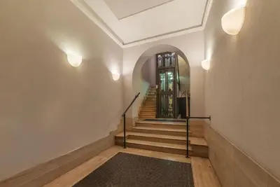 a hallway with stairs with a door and a rug at Trevi Garden Suite in Rome