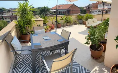 a patio with a table and chairs on a balcony at Chic Penthouse Retreat in Rome