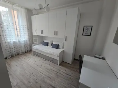 a bedroom with a bed with white cabinets and blue pillows at Di Lollo Comfort Suites in Rome