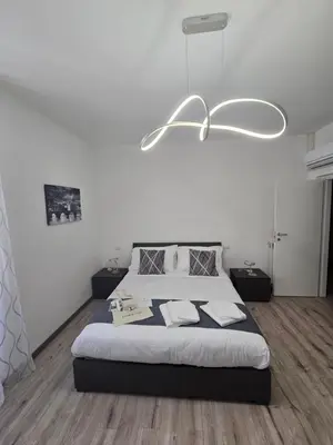 a bedroom with a large bed and a white wall at Di Lollo Comfort Suites in Rome