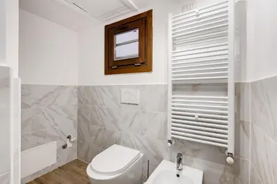 a white bathroom with a toilet and a window at New Spanish Square - RomeDreamHome in Rome
