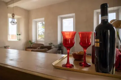 a bottle of wine and two red wine glasses on a counter at Labicasa in Rome
