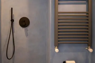 a hat is on the wall of a bathroom at Labicasa in Rome