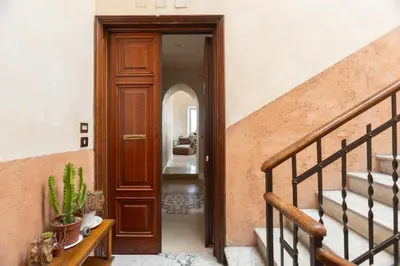 a hallway with a wooden door and stairs at Labicasa in Rome