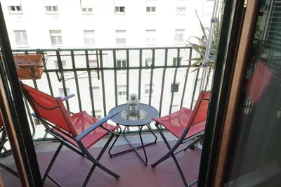 a patio with two chairs and a table on a balcony at Stazione Trastevere 3BR Flat by Flatinrome in Rome