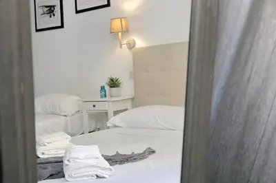 a reflection of a bedroom with a bed and a mirror at 4BNB - Otello in Rome