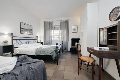 a bedroom with two beds and a desk and a table at 4BNB - Otello in Rome