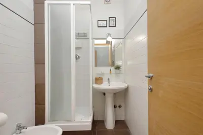 a white bathroom with a sink and a mirror at 4BNB - Otello in Rome