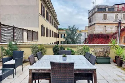 a patio with a table and chairs on a balcony at Fidelio Holiday Home in Rome