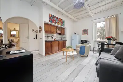 a living room with a couch and a kitchen at Fidelio Holiday Home in Rome