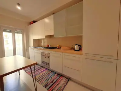 a kitchen with white cabinets and a table at Sophìa, City Retreat near Vatican in Rome