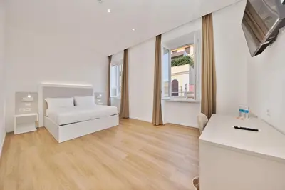 a white living room with a couch and a window at LH Hotel Andreotti in Rome