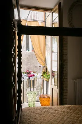 a bedroom with a window with flowers on a balcony at Nerva Accommodation Cavour in Rome