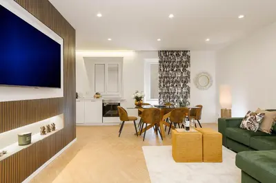 a living room with a green couch and a dining room at Eden Luxury Apartment in Rome