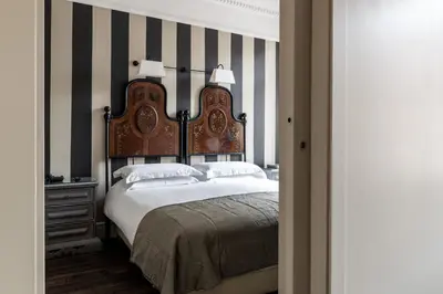 a bedroom with a large bed and a striped wall at Casa Montani in Rome