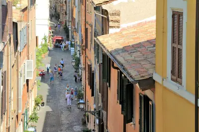 a group of people walking down a street between buildings at Residenza Torre Vecchiarelli - apt 4 in Rome