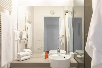a white bathroom with a sink and a mirror at Residenza Torre Vecchiarelli - apt 4 in Rome