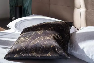 a brown pillow sitting on top of a bed at Roma Design Rooms San Giovanni Colosseo Area in Rome