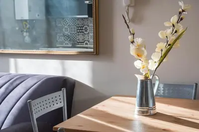 a vase with white flowers on a wooden table at Roma Design Rooms San Giovanni Colosseo Area in Rome