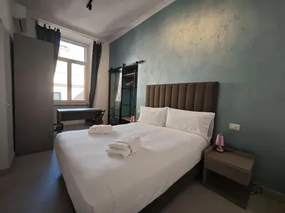 a bedroom with a large white bed with towels on it at Appartamento Alida in Rome