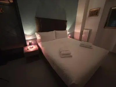 a bedroom with a large white bed with two lights at Appartamento Alida in Rome