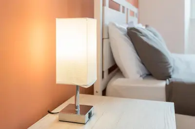 a lamp sitting on a table next to a bed at Vista Laterana in Rome