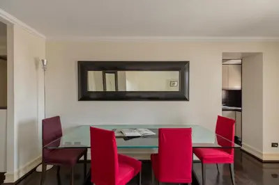 a dining room with a glass table and red chairs at Celeste Retreat al Pantheon - Homkeey Apartments in Rome