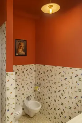 a bathroom with orange walls and a toilet and a sink at Aurelio APT - Homkeey Apartments in Rome