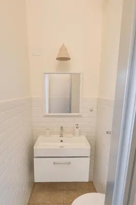 a white bathroom with a sink and a mirror at Aurelio APT - Homkeey Apartments in Rome