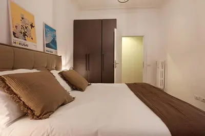 a bedroom with a large white bed with brown pillows at Bologna Garden House in Rome