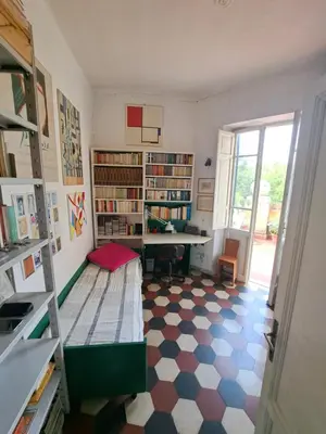 a room with a desk and bookshelves at Terrazza Trastevere Apartment in Rome