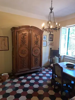 a large wooden cabinet in a room with a table at Terrazza Trastevere Apartment in Rome