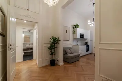 a living room with a couch and a kitchen at Castro Pretorio 9 - FromHometoRome in Rome