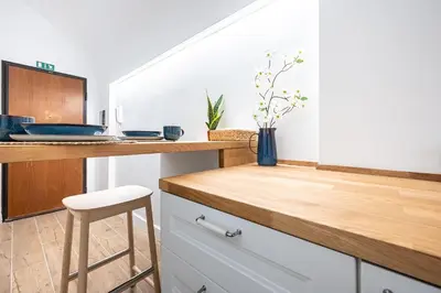 a kitchen with white cabinets and a counter with a stool at Domus Piramide in Rome