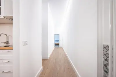 a hallway leading into a kitchen with white walls and wood floors at Domus Piramide in Rome