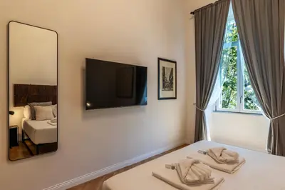 a bedroom with a bed with a mirror and a tv at Castro Pretorio 21 - FromHometoRome in Rome