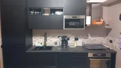 a kitchen with black cabinets and a counter top at Bilocale EUR Grotta Perfetta 50mq casa 32mq sala hobbies e 250mq giardino in Rome