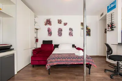 a bedroom with a bed and a red couch at Cottage with Garden and Terrace near Termini in Rome