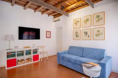 a living room with a blue couch and a tv at Elegantis Josephine Suite - Elegance near Spanish Steps Trevi and Pantheon in Rome