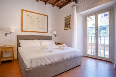 a bedroom with a bed and a large window at Elegantis Josephine Suite - Elegance near Spanish Steps Trevi and Pantheon in Rome