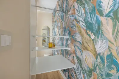 a bathroom with a mural of leaves on the wall at Colosseum Essence - Homkeey Apartments in Rome