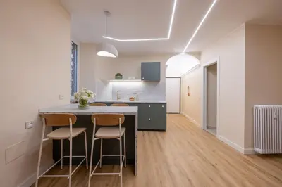 a kitchen with a counter and two stools at Colosseum Essence - Homkeey Apartments in Rome