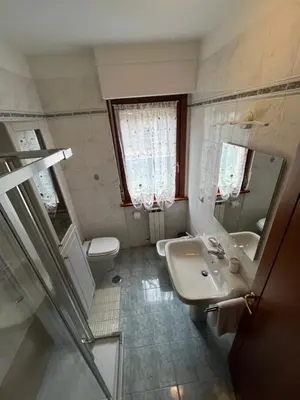 a bathroom with a sink and a toilet and a mirror at Trilocale con terrazza e garage in Rome