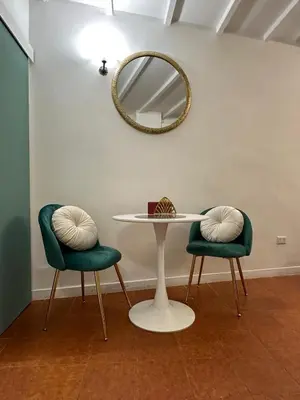 a table with two green chairs and a mirror at incanto e campo de fiori in Rome