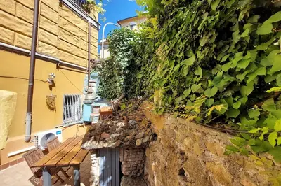 a wooden bench sitting next to a stone wall at Casa Gaudì in Rome